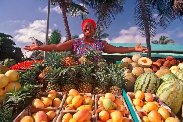 Чернокожая женщина с ящиками фруктов