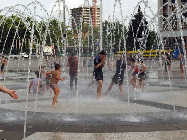 Дети купаются в фонтане